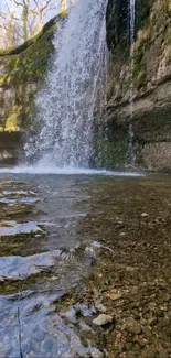 Picture of a serene waterfall cascading over rocky cliffs into a clear stream.