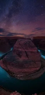 Canyon at night with a star-filled sky and vivid twilight colors.