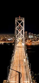 A nighttime view of a bridge with city lights in the background.