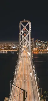 Nighttime view of a city skyline and bridge under dark sky.