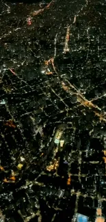 Aerial night view of brightly lit cityscape, showcasing intricate street patterns.