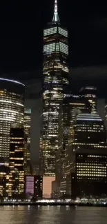 Night cityscape with illuminated buildings reflecting over water.