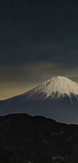 Snow-capped mountain under starry night sky.