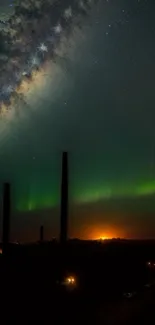 Vibrant aurora under a starry sky with silhouetted trees.