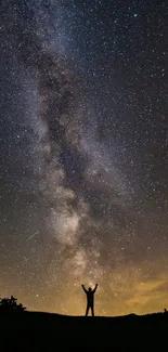 Silhouette under a stunning starry night sky featuring the Milky Way.