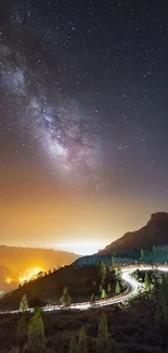 Night sky with Milky Way over mountains and winding road wallpaper.