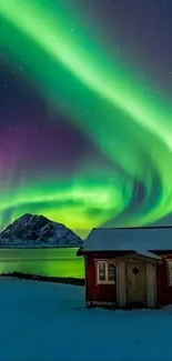 Mobile wallpaper of green Northern Lights over a snowy landscape with a red cabin.