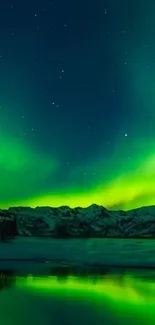 Vibrant green aurora over snow-capped mountains and reflective water under a starry sky.