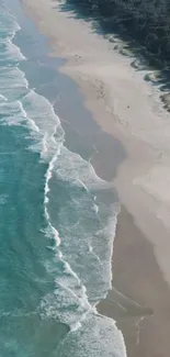 Aerial view of turquoise ocean waves lapping a sandy beach.