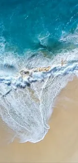 Aerial view of ocean waves crashing on a sandy beach with vibrant blue waters.