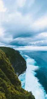 Breathtaking view of ocean waves crashing against lush green cliffs under a cloudy sky.