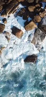 Aerial view of ocean waves crashing against rocks on the shore.