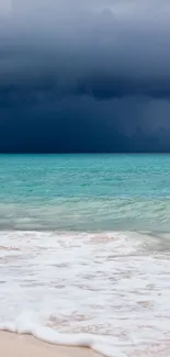 Stormy ocean beach wallpaper with turquoise seas and dark skies.