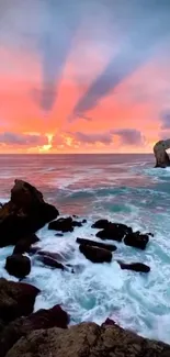 Sunset over ocean with rocks and vibrant sky.