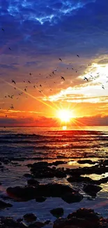 Vibrant sunset over ocean with birds flying in the sky.