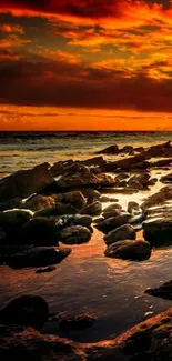 Fiery ocean sunset over rocky shores wallpaper.