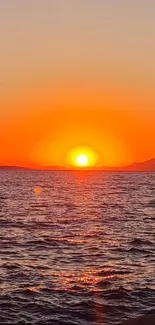 Fiery sunset over ocean horizon with vibrant orange glow