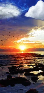 Vibrant ocean sunset with birds flying over tranquil waters and clouds.