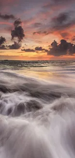 Vibrant ocean sunset with waves and rocks under a colorful sky.