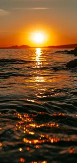 Ocean sunset with glowing orange sky over calm water, perfect for mobile wallpaper.