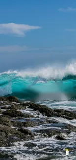 Turquoise wave crashing over rocks under a clear sky.