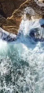 Aerial view of ocean waves crashing against rocks, featuring vibrant blue hues.