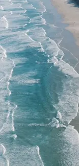 Aerial view of ocean waves crashing onto a sandy beach.