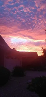 Vibrant pink sunset sky over a quiet residential neighborhood.