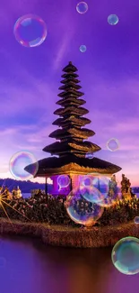 Balinese temple at twilight with vibrant purple sky and serene water reflection.