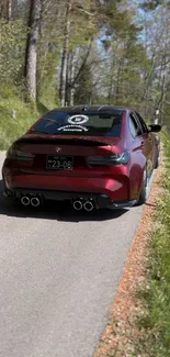 Red sports car on forest road wallpaper.