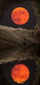 Red moon reflecting in water framed by rocky cave.