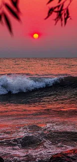 Red sunset over ocean waves with vibrant sky.