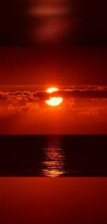 Vivid red sunset over an ocean with reflection.