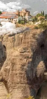 Elephant-shaped rock with village on top in serene mountain setting.