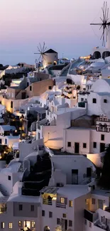 Santorini buildings and windmills at dusk, showcasing a stunning evening view.