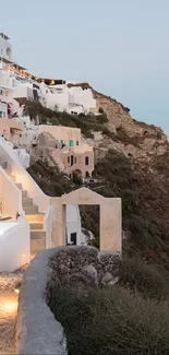 Santorini cliffside view with white buildings and sea backdrop.