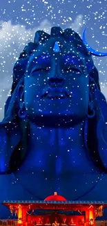 Majestic Shiva statue under starry night sky.