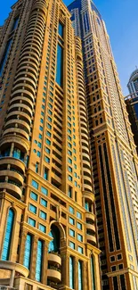 Tall skyscraper buildings under a blue sky reflecting golden hues.