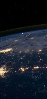 Earth from space at night with illuminated continents.