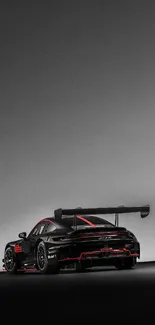 Black sports car with red accents on a gray background, sleek and aerodynamic.