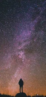 Silhouette against starry purple night sky.