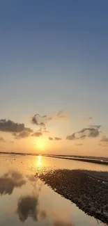 Sunset over a tranquil beach with vibrant sky reflections.