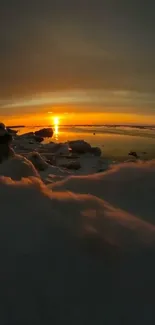 A stunning sunset over a snowy beach with vibrant orange hues and serene waters.