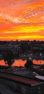 Orange sunset cityscape reflecting in river.