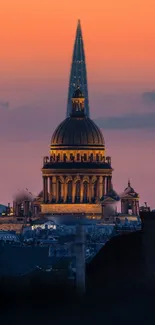 Dome and spire against a sunset cityscape, capturing urban architecture.