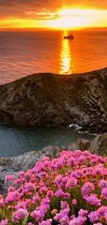 Pink flowers and sunset over ocean with a cliff view.