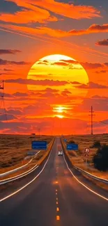 Highway leading into a vibrant orange sunset.