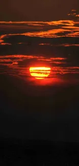 Vibrant orange sunset with clouds over a serene sky.
