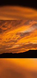 Orange sunset over mountains with dramatic clouds.