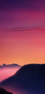 Vivid sunset over misty mountains with a purple and orange night sky.